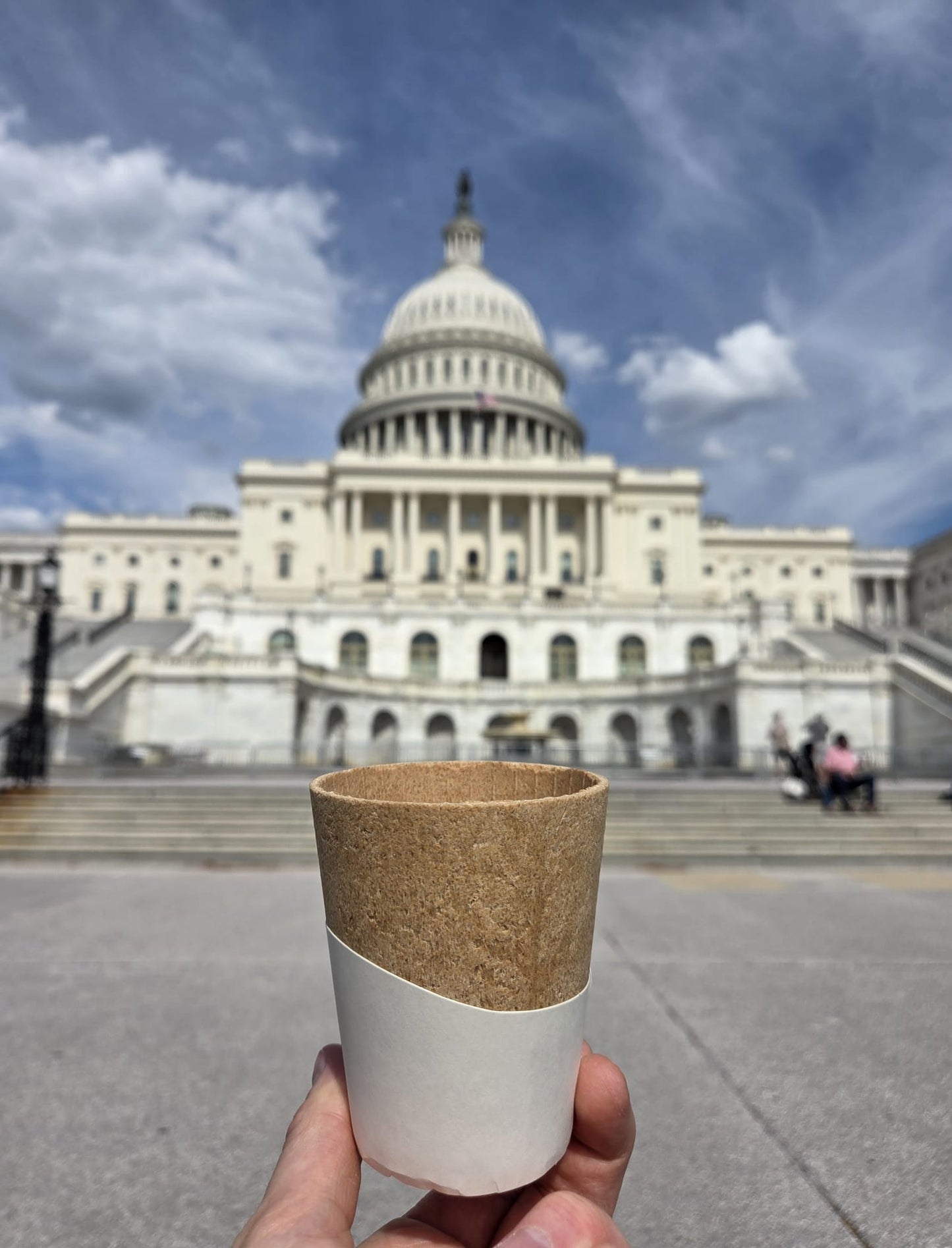 Cork and white cup held in front of the U.S. Capitol building