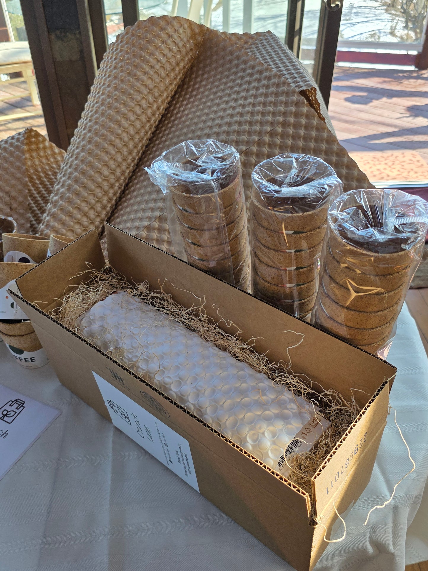 Box with bubble-wrapped rolls of paper on a white surface